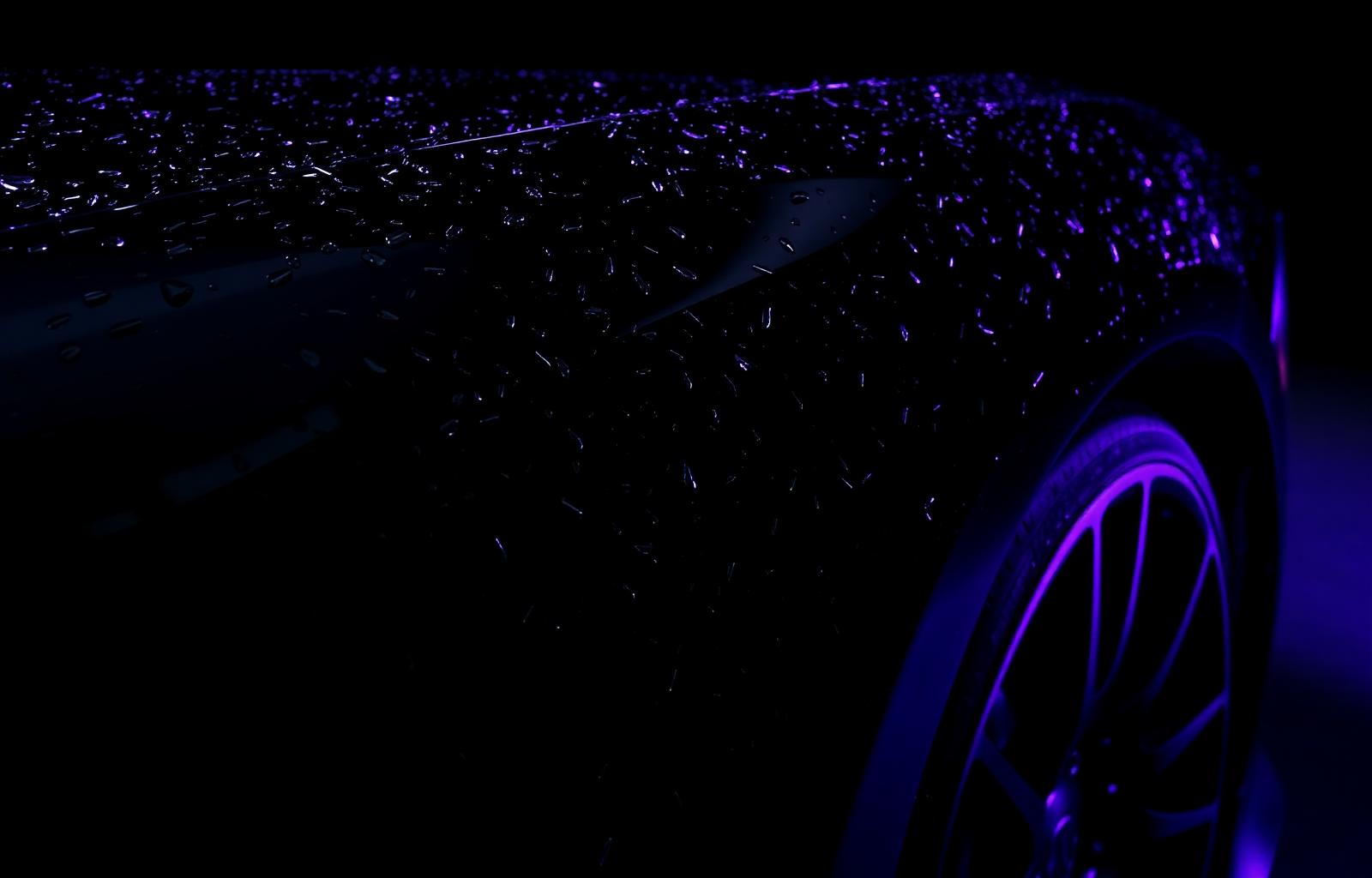 Glossy black car after professional detailing with purple light accents